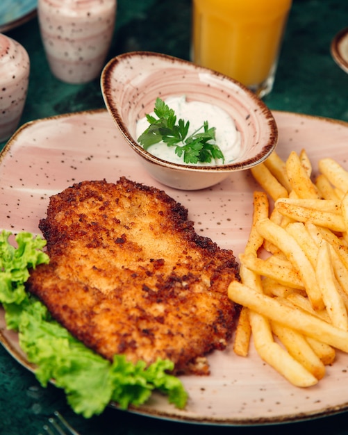 Peito de frango grelhado e servido com batata frita, maionese e alface.