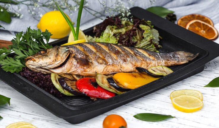Foto grátis peixe assado adornado com fatias de limão servido com legumes