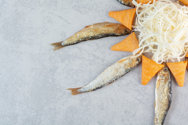 Foto grátis peixe com queijo e batatas fritas amarelas em cinza.