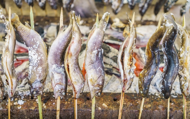 Peixe com sal que estão sendo grelhados ao ar livre no Japão