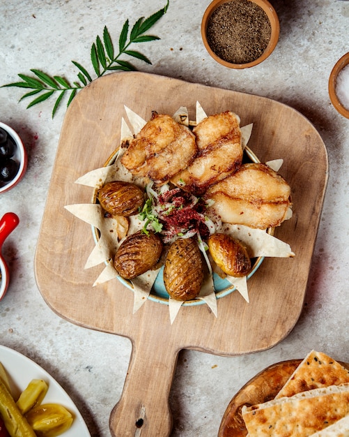 Peixe frito com batatas assadas e cebolas