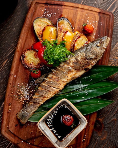 peixe frito com berinjelas grelhadas pimentas tomates e molho
