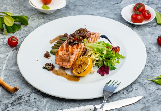 peixe frito com legumes em cima da mesa