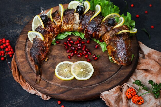 Peixe grelhado com ervas, frutas, limão