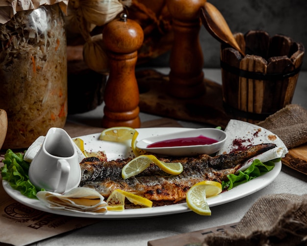 Peixe grelhado com limão e molho de tomate.