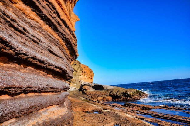 Penhascos na frente da água sob um céu azul claro na Espanha