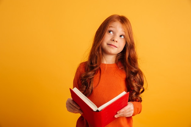 Foto grátis pensando menina ruiva lendo livro