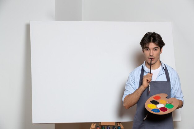 Pensando o artista masculino começando sua nova pintura de fundo branco desenhando arte