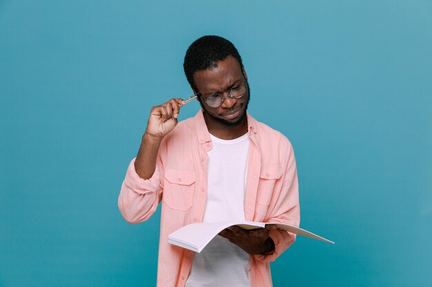Pensando segurando o notebook jovem afro-americano isolado em fundo azul