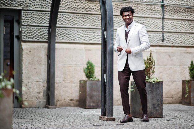 Pensativo e bonito cavalheiro afro-americano em roupas formais Modelo preto elegante homem de jaqueta branca