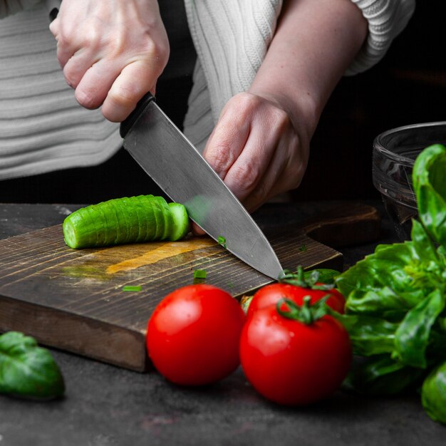 Pepino de corte de mulher na mesa