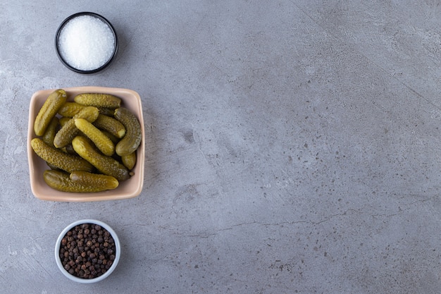 Pepinos em conserva marinados deliciosos colocados na mesa de pedra.