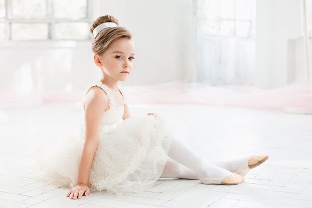 pequena bailarina com tutu branco na escola de balé