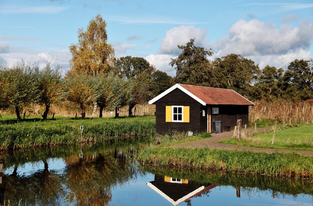 Pequena casa de madeira perto do lago em uma área rural