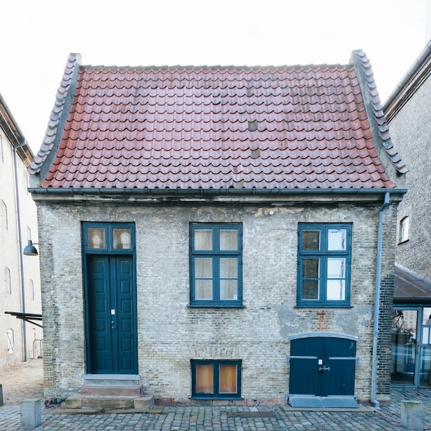 Pequena casa de tijolos com telhado de azulejos