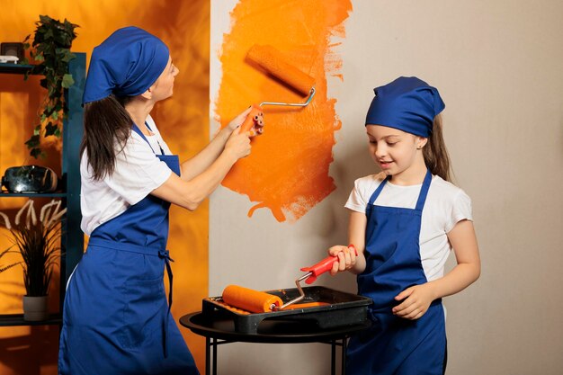 Pequena família pintando paredes laranja