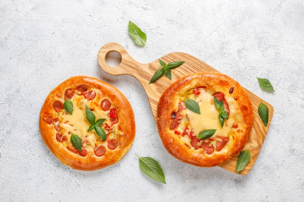 Foto grátis pequenas pizzas caseiras frescas com manjericão.
