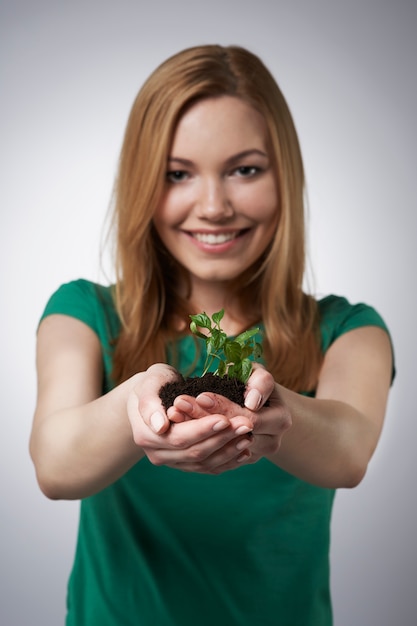 Foto grátis pequenas plantas nas mãos de mulheres