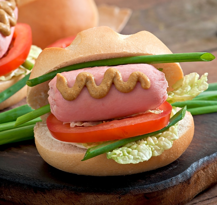 Foto grátis pequeno cachorro-quente alegre com salsicha e tomate