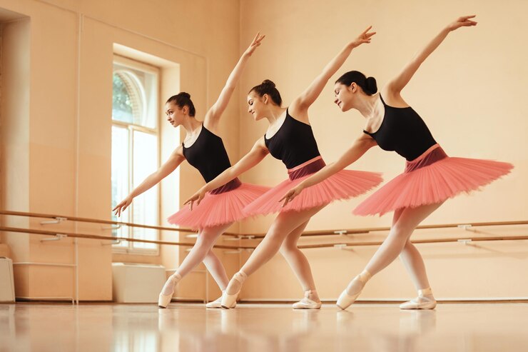 Foto grátis pequeno grupo de bailarinas dançando durante o ensaio na escola de balé