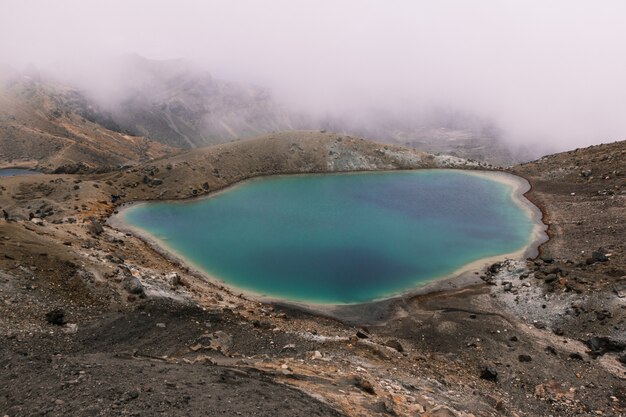 Pequeno lago no meio do deserto, perto de uma montanha em um dia nebuloso