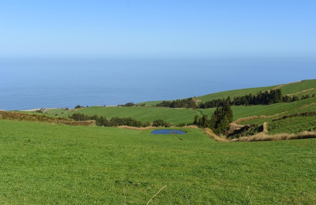 Pequeno lago num campo relvado ao longo da costa dos Açores.