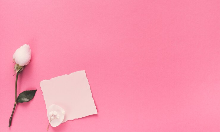 Foto grátis pequeno papel em branco com flor branca na mesa-de-rosa