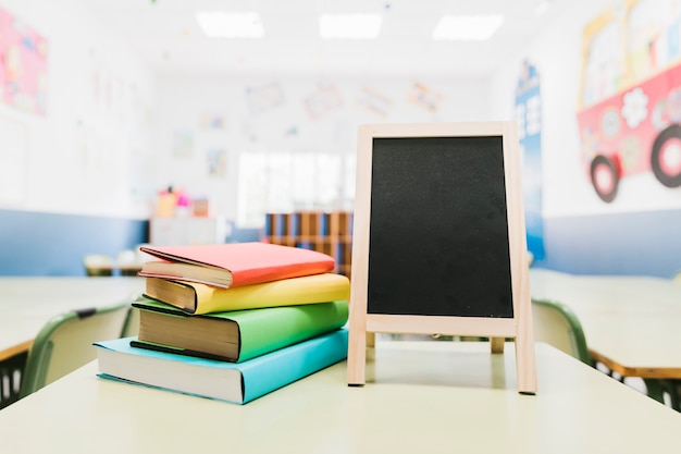 Pequeno quadro-negro e livros didáticos na mesa