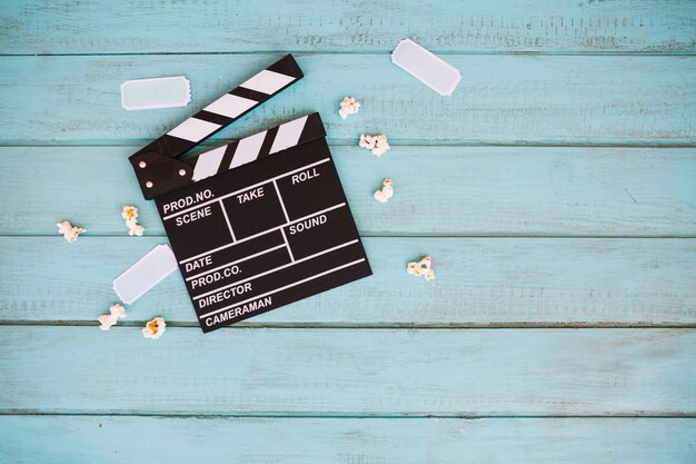 Pequenos bilhetes e pipoca perto do clapperboard