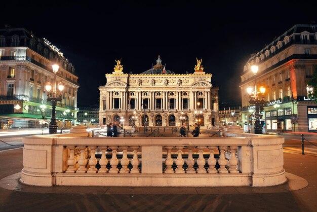 Ópera de Paris à noite como a famosa atração turística e marco da cidade.