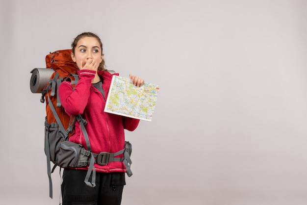 Foto grátis perguntou o jovem viajante com uma mochila segurando um mapa em cinza