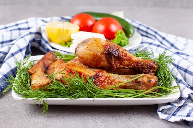 Pernas de frango assadas com verduras em um prato branco