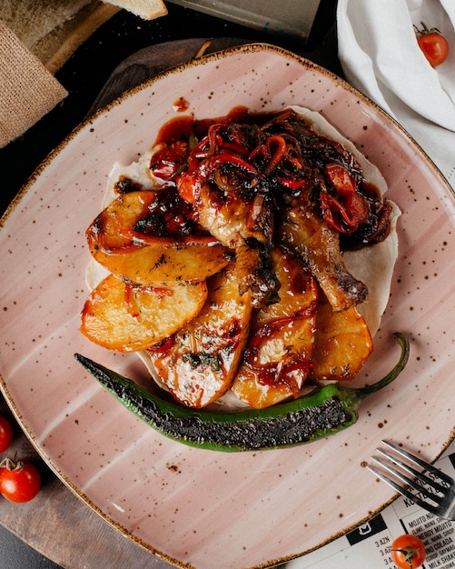 Foto grátis pernas de frango grelhado com batatas grelhadas cebola tomate picante e pimentão na pita