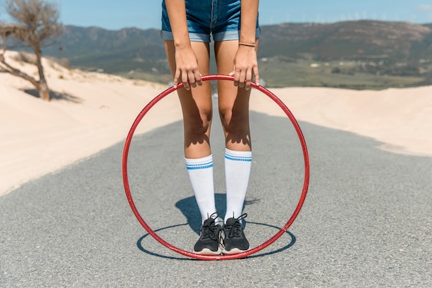 Pernas de mulher com bambolê na estrada