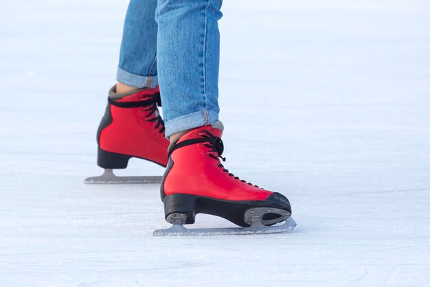 Pernas de uma mulher patinando no gelo em uma pista de gelo. passatempos e lazer. esportes de inverno