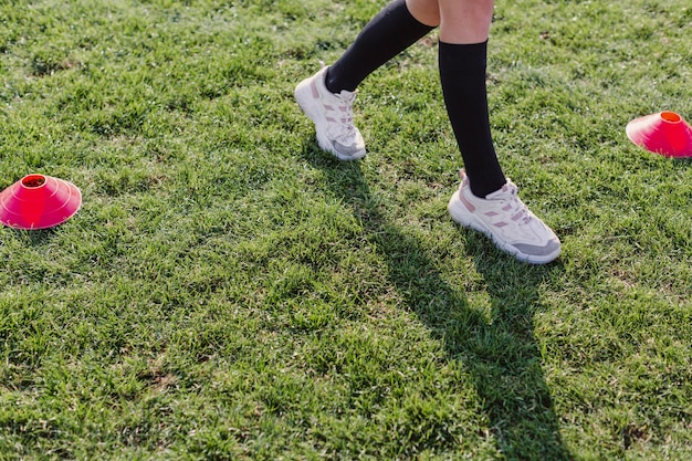 Pernas femininas andando através de cones