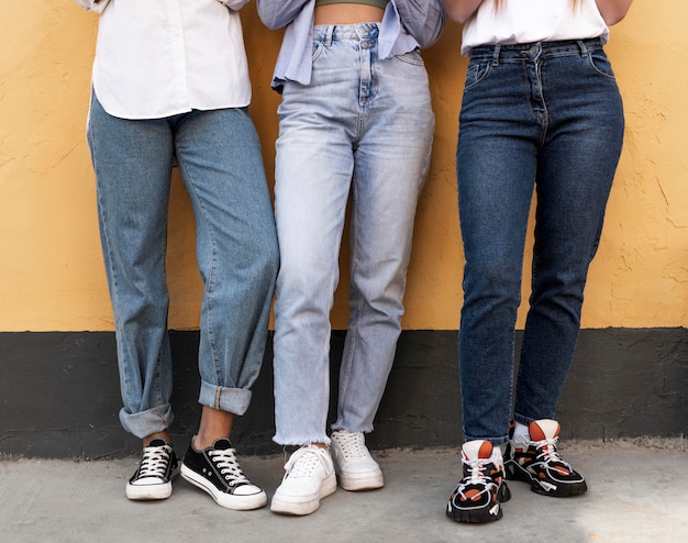 Pernas femininas em frente a uma parede amarela