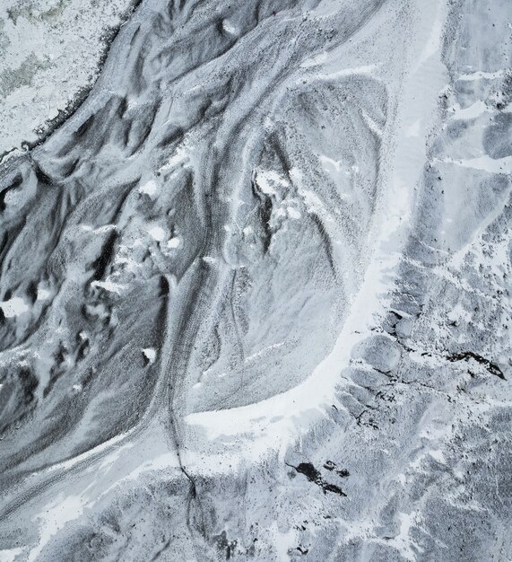 Perspectiva aérea de cima para baixo do caminho gelado que leva à base do glaciar Sólheimajökull