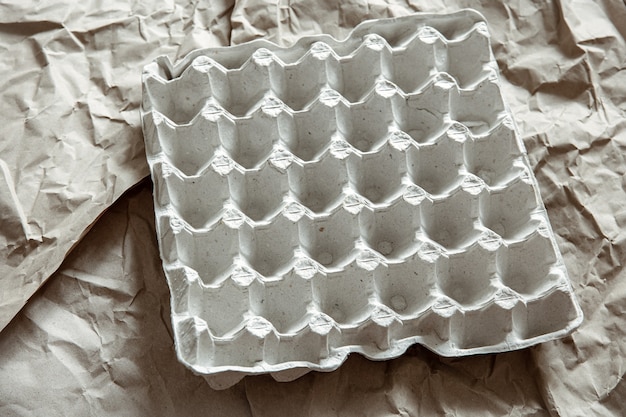 Foto grátis perto da bandeja de ovos vazia de papel amassado. o conceito de reciclagem, reutilização.