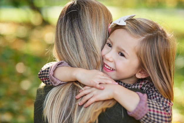 Foto grátis perto da garota feliz abraçando a mamãe