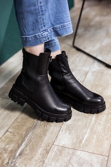Perto de botas femininas negras. botas de couro elegantes para mulheres na moda. Foto Premium