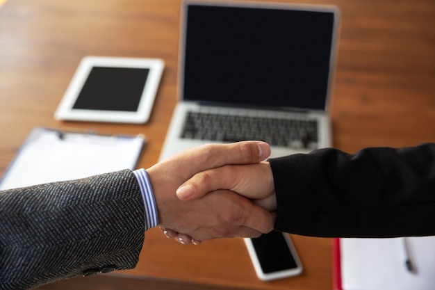 Perto de empresários apertando as mãos na sala de conferências