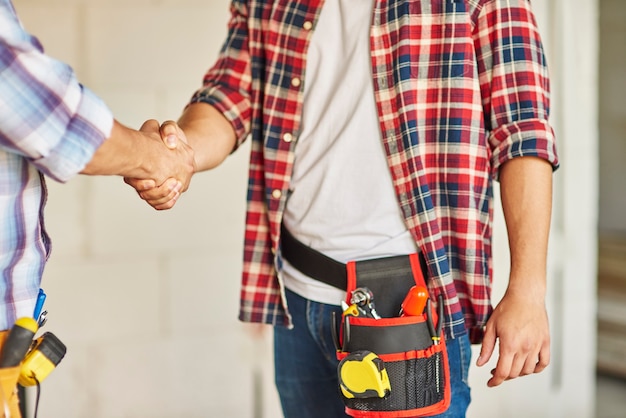 Perto de trabalhadores cooperando e apertando as mãos