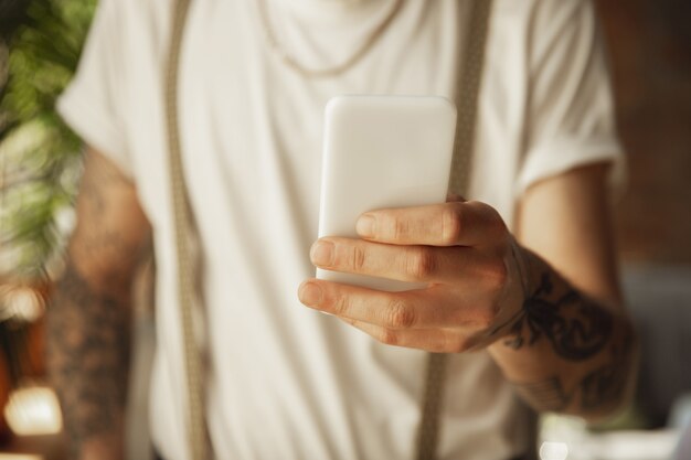 Perto de um homem estiloso usando smartphone, tirando uma selfie