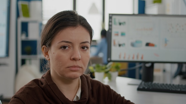 Foto grátis perto de uma mulher de negócios com deficiência parecendo triste na frente, enquanto uma equipe diversificada trabalha em um projeto financeiro