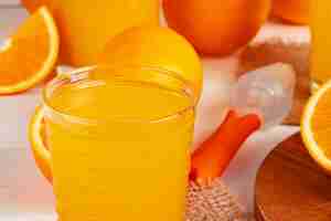 Foto grátis perto do copo de suco de laranja na mesa de madeira