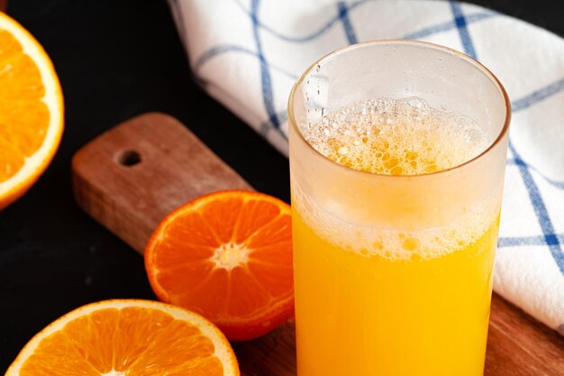 Perto do copo de suco de laranja na mesa de madeira