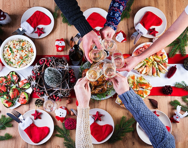 Peru assado. Ceia de Natal. A mesa de Natal é servida com peru, decorada com enfeites brilhantes e velas. Frango frito, mesa. Jantar em família. Vista superior, mãos na moldura