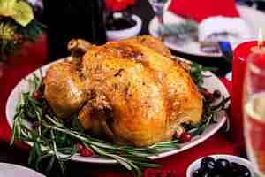 Foto grátis peru assado. ceia de natal. a mesa de natal é servida com um peru, decorado com enfeites e velas brilhantes. frango frito, mesa. jantar em família.