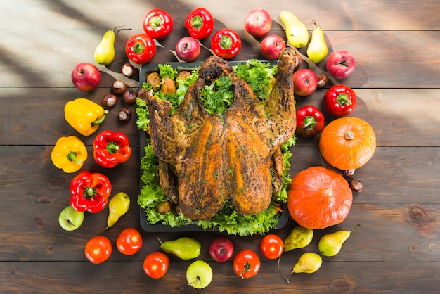 Peru assado com legumes na mesa de madeira